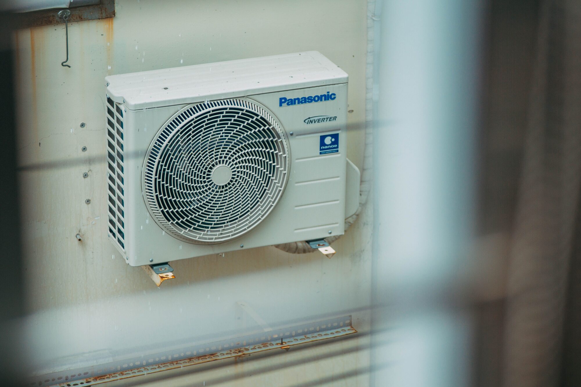 Modern outdoor mini-split condenser mounted on an exterior wall