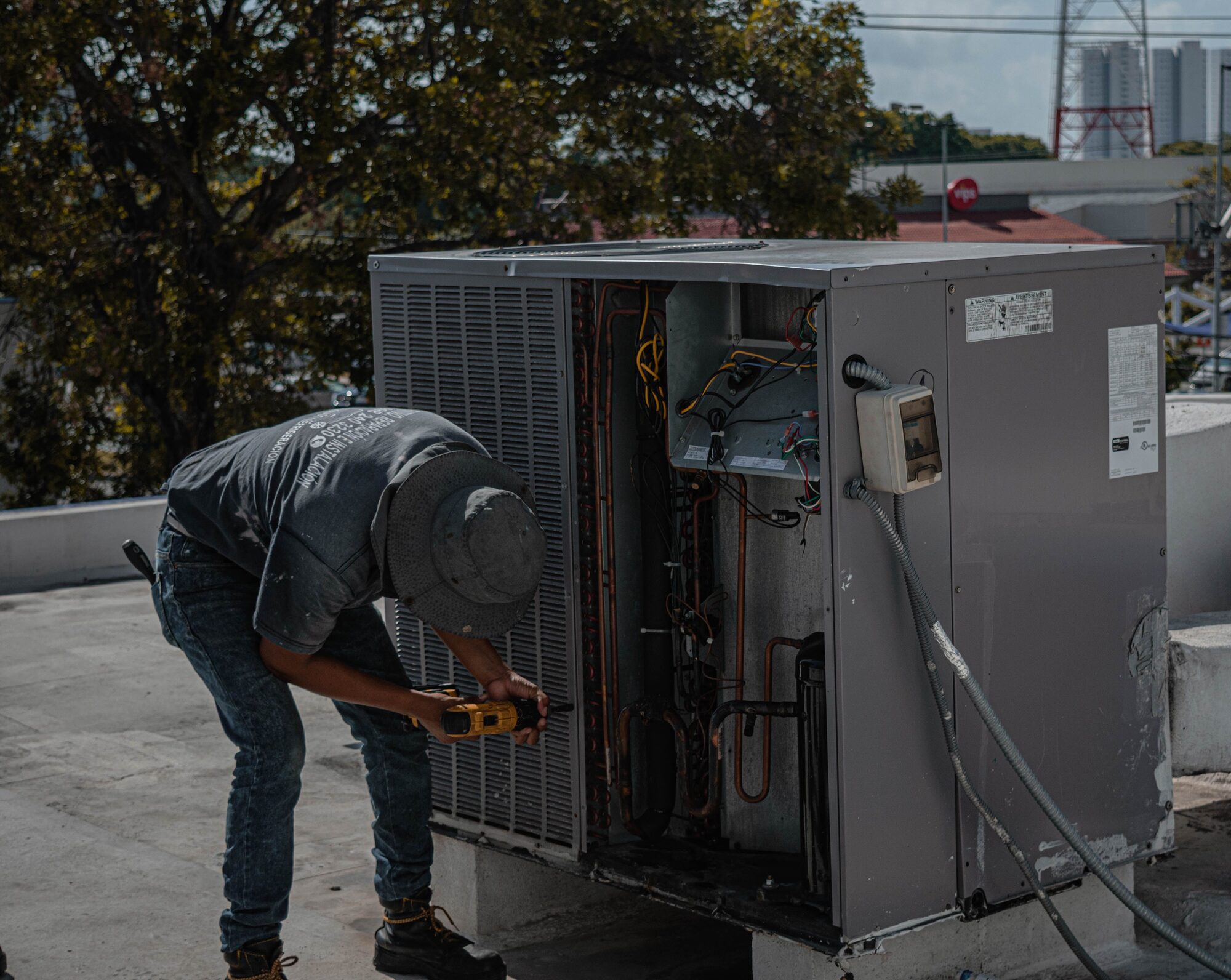 Technician servicing a rooftop commercial HVAC unit