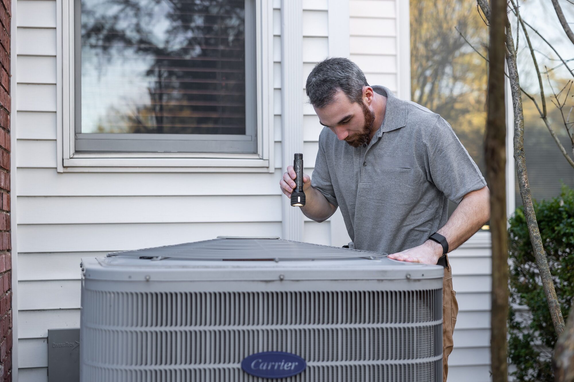 HVAC technician repairing an outdoor condenser unit